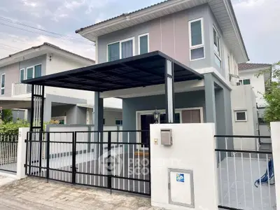 Modern two-story house with sleek design and spacious driveway in suburban neighborhood.