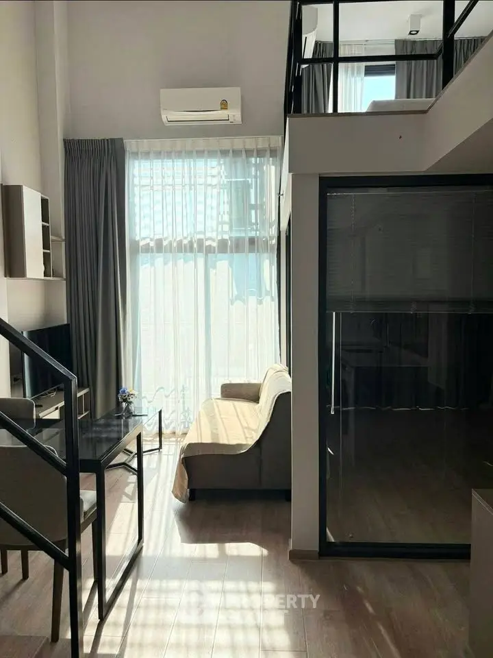 Modern loft apartment with high ceilings and natural light, featuring a cozy living area and stylish mezzanine.