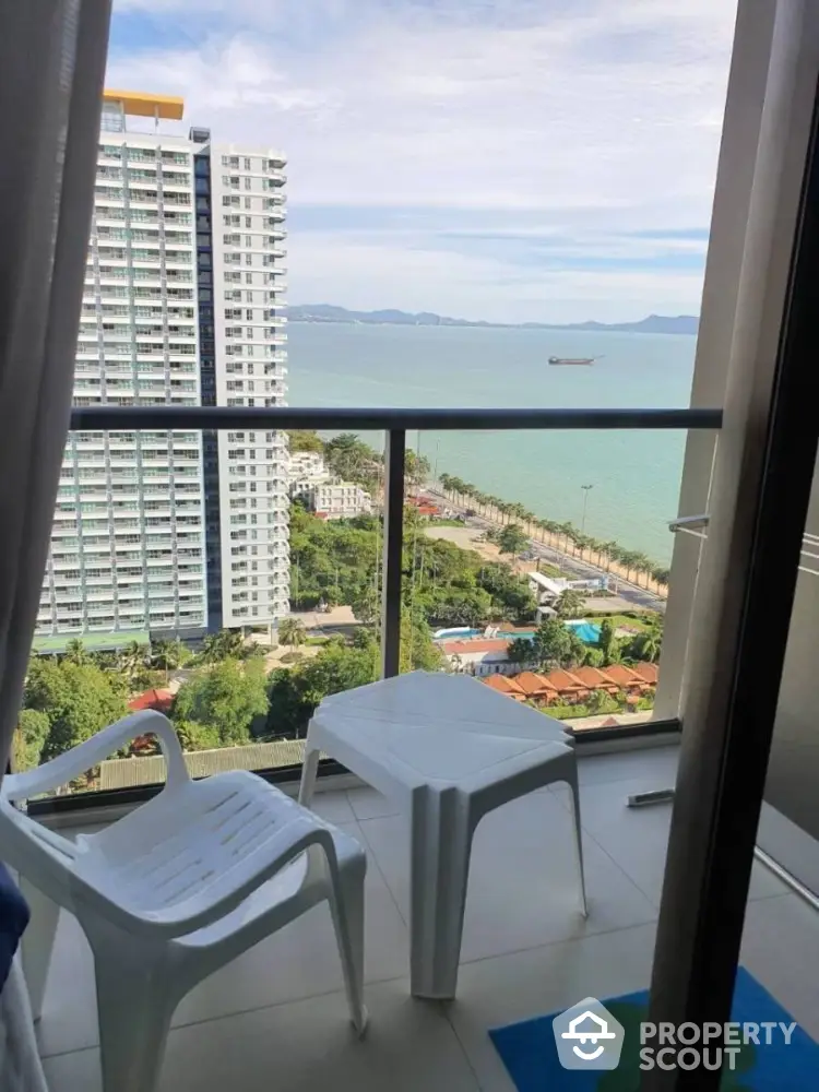 Stunning balcony view overlooking ocean and city skyline, perfect for relaxation.