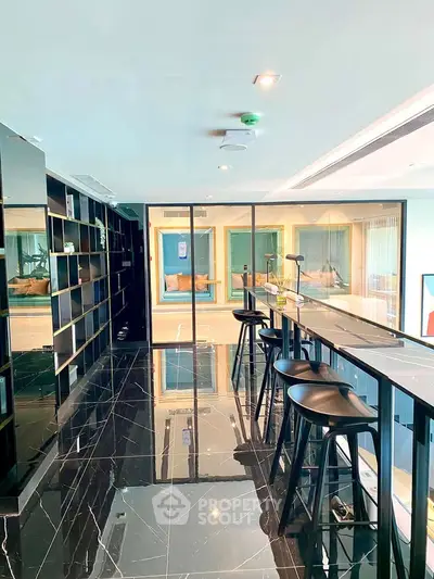 Luxurious modern living room with sleek black marble flooring and stylish bar seating area.