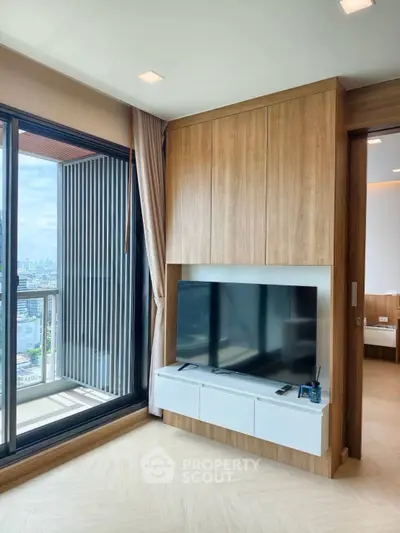 Modern living room with large TV and city view balcony in luxury apartment