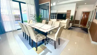 Spacious modern dining and living area with elegant decor and large windows.