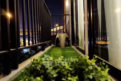 Charming balcony with artificial grass and night city view, perfect for relaxation and enjoying urban life.