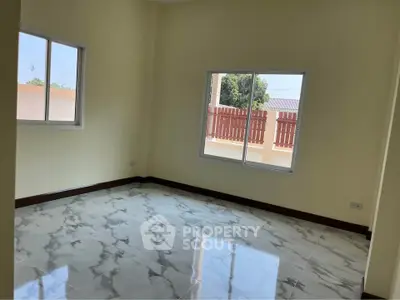 Spacious empty room with large windows and marble flooring, perfect for customization.