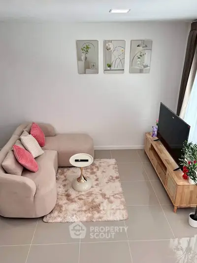 Chic living room with cozy sofa, stylish decor, and modern TV setup.