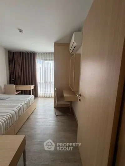 Modern bedroom with minimalist design, featuring a bed, desk, and large window with curtains.