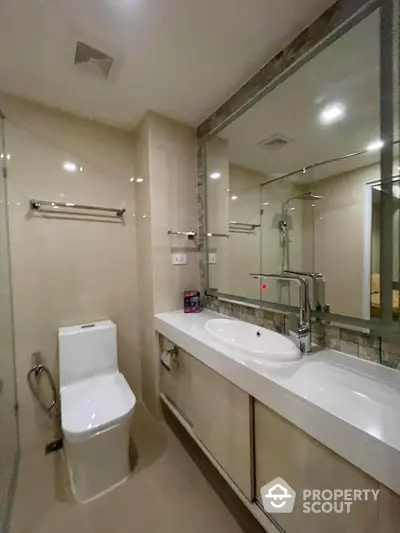 Modern bathroom with sleek fixtures and large mirror in contemporary apartment