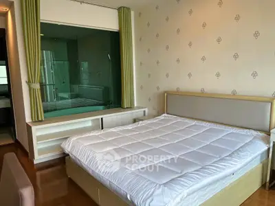 Spacious bedroom with modern decor and large window overlooking bathroom