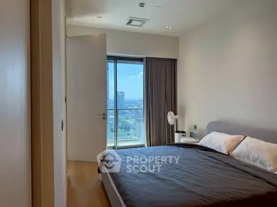 Modern bedroom with large window offering stunning city view