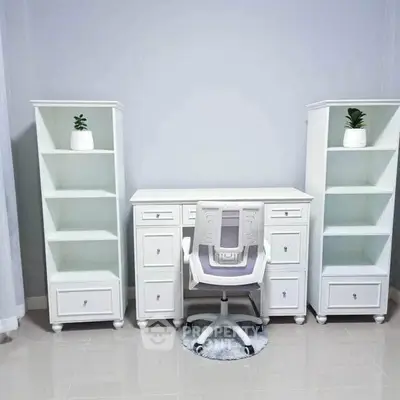 Elegant home office setup with white desk, chair, and shelves for a modern workspace.