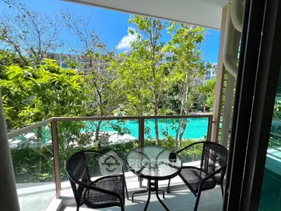 Charming balcony view overlooking lush greenery and a sparkling pool, perfect for relaxation.
