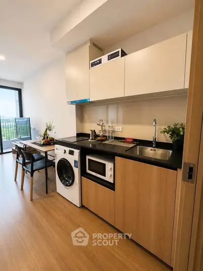 Modern kitchen with washing machine and dining area in stylish apartment