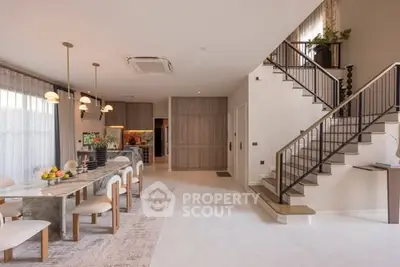 Spacious modern living room with elegant dining area and stylish staircase, perfect for family gatherings.