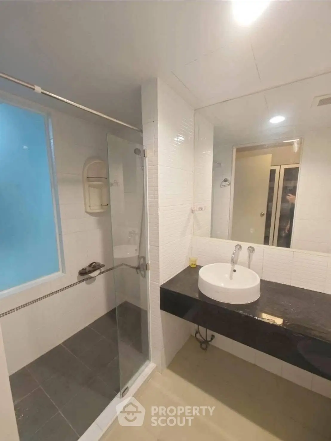 Modern bathroom with glass shower and sleek black countertop