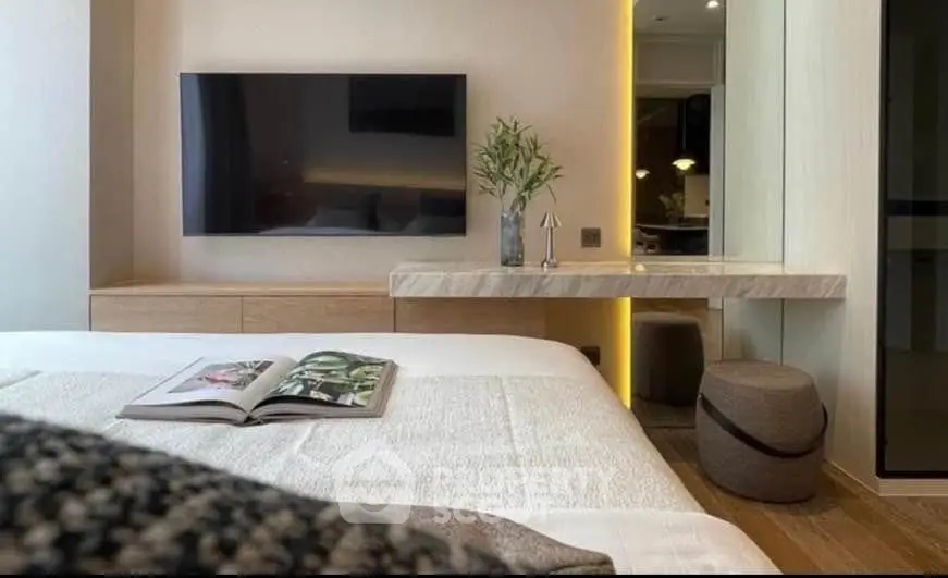 Modern bedroom with wall-mounted TV and stylish decor, featuring a cozy bed and elegant lighting.