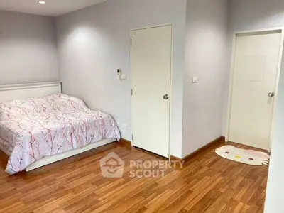 Spacious bedroom with wooden flooring and cozy bed in modern apartment