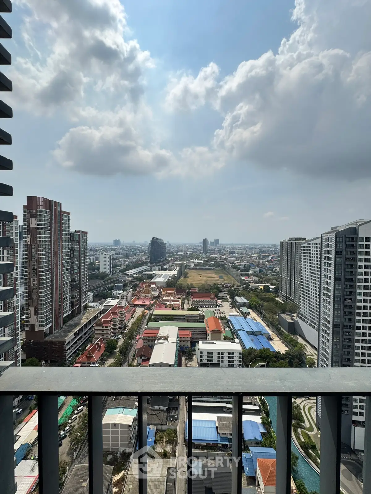 Stunning cityscape view from a high-rise balcony showcasing urban skyline and expansive horizon.