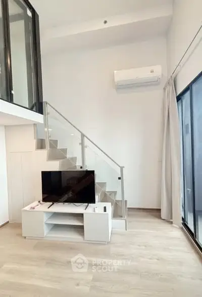 Modern duplex living room with sleek staircase and large windows