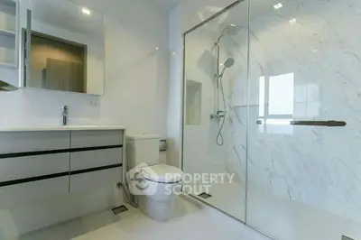 Modern bathroom with glass shower and sleek vanity in luxury home.