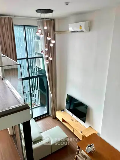 Modern loft-style living room with high ceiling and large windows offering city views.
