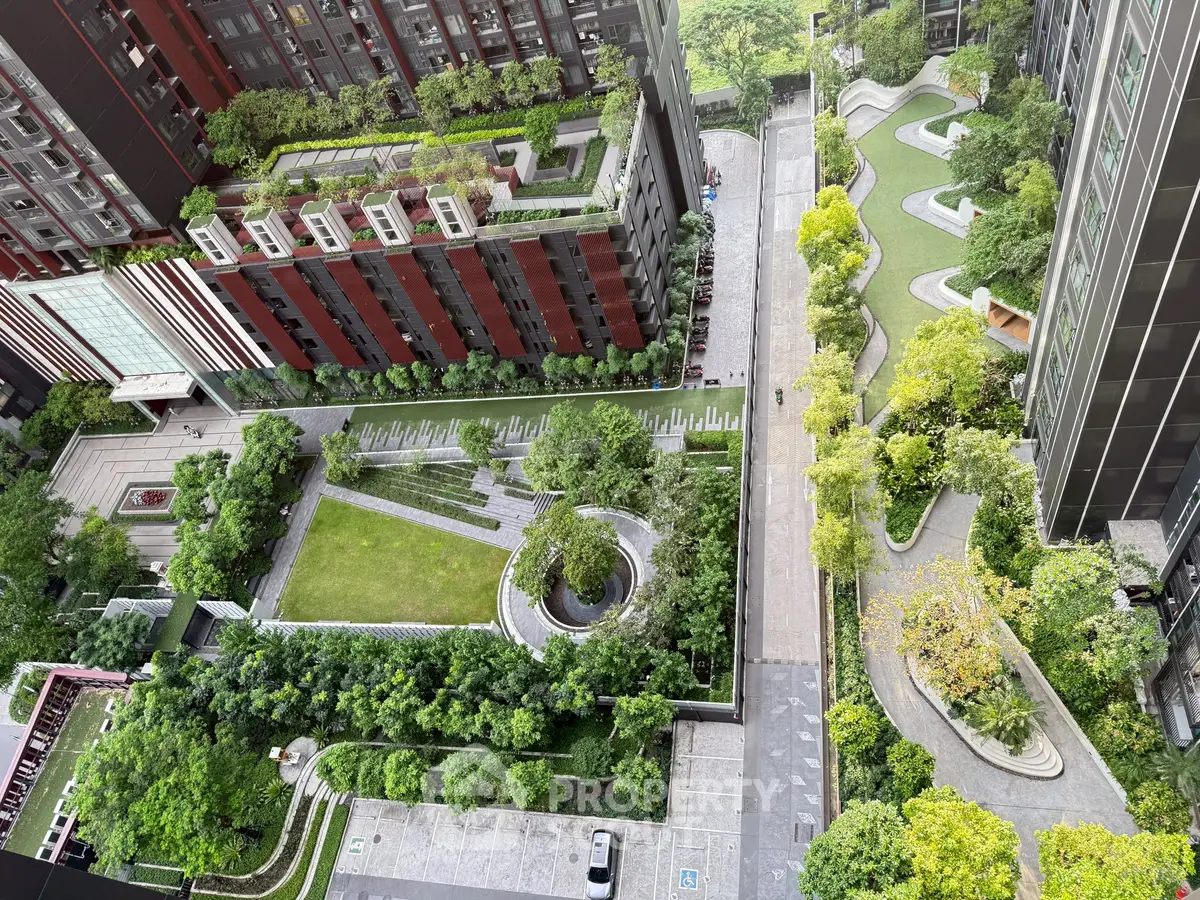 Stunning aerial view of modern residential complex with lush green gardens and pathways.