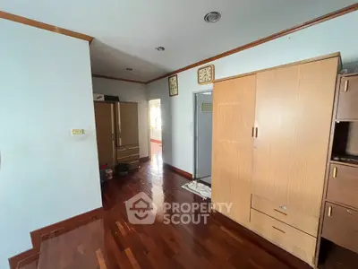 Spacious bedroom with wooden flooring and ample storage space