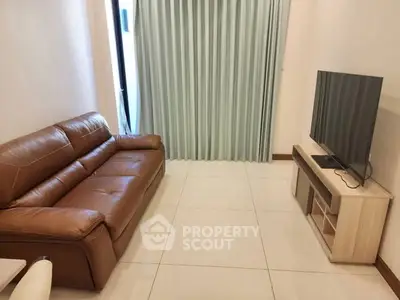 Cozy living room with leather sofa and modern TV setup, perfect for relaxation.