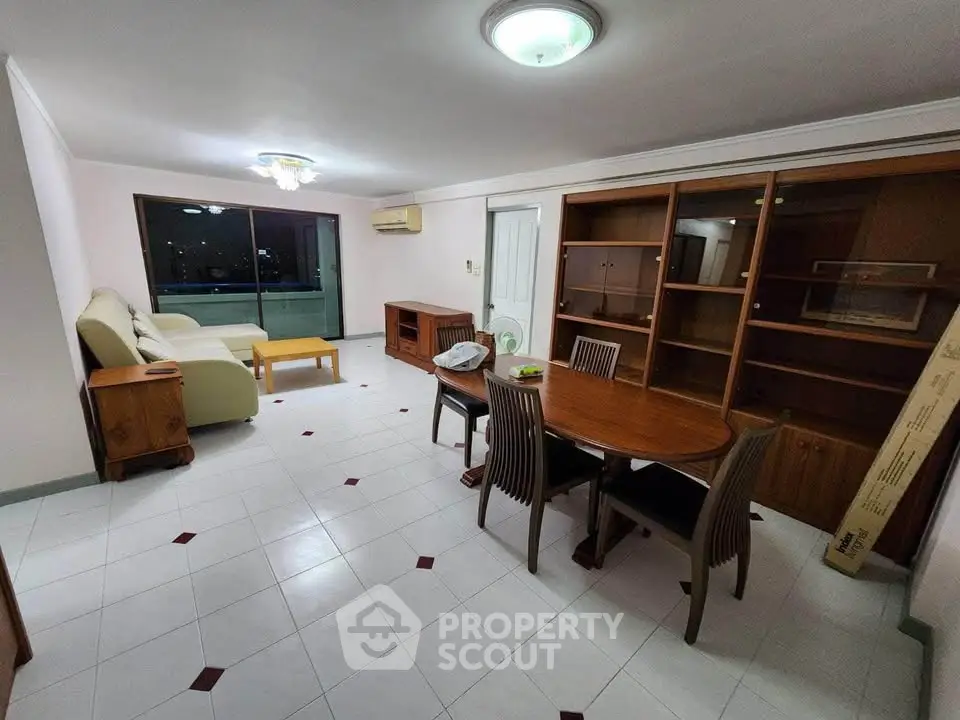 Spacious living room with dining area and large window offering city views.