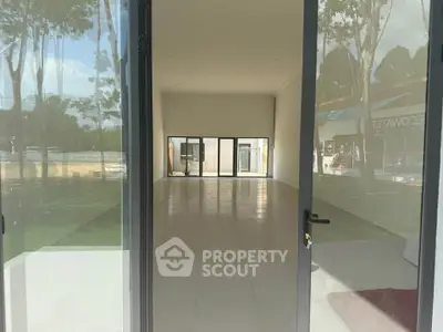 Spacious empty commercial space with large windows and tiled flooring, ideal for retail or office setup.