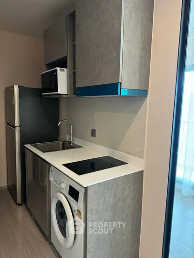 Modern compact kitchen with washing machine and sleek appliances