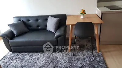 Cozy living room with black leather sofa and wooden table, perfect for modern living.