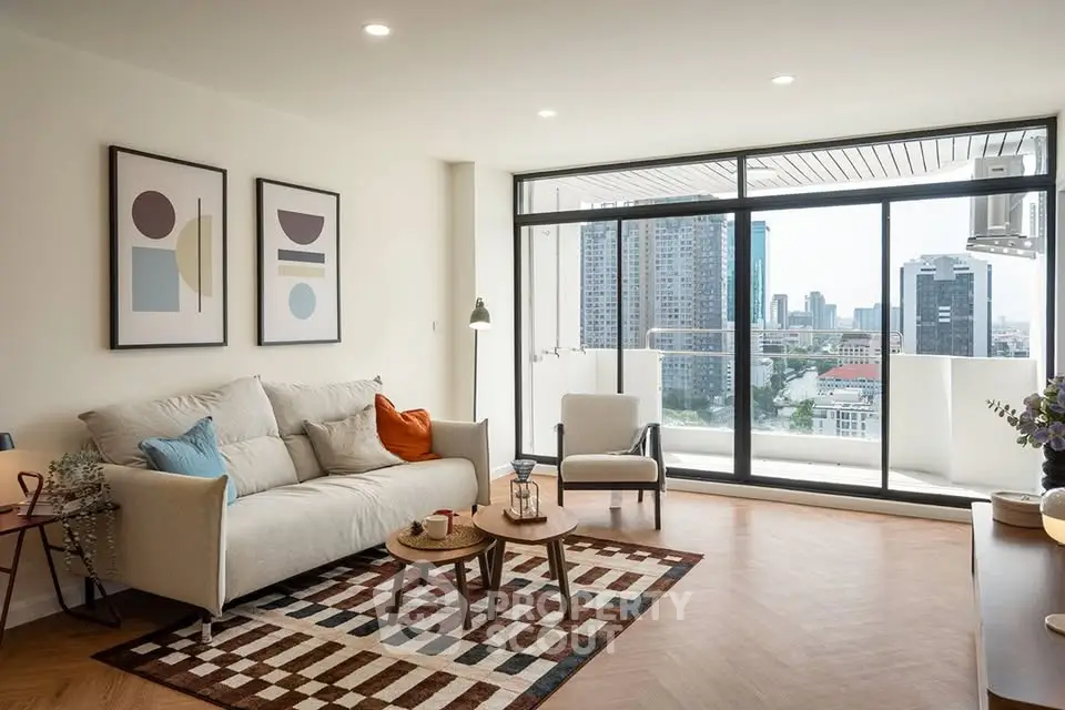 Modern living room with large windows and city view, featuring stylish decor and cozy seating area.