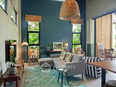 Spacious living room with modern decor and large windows overlooking lush greenery.
