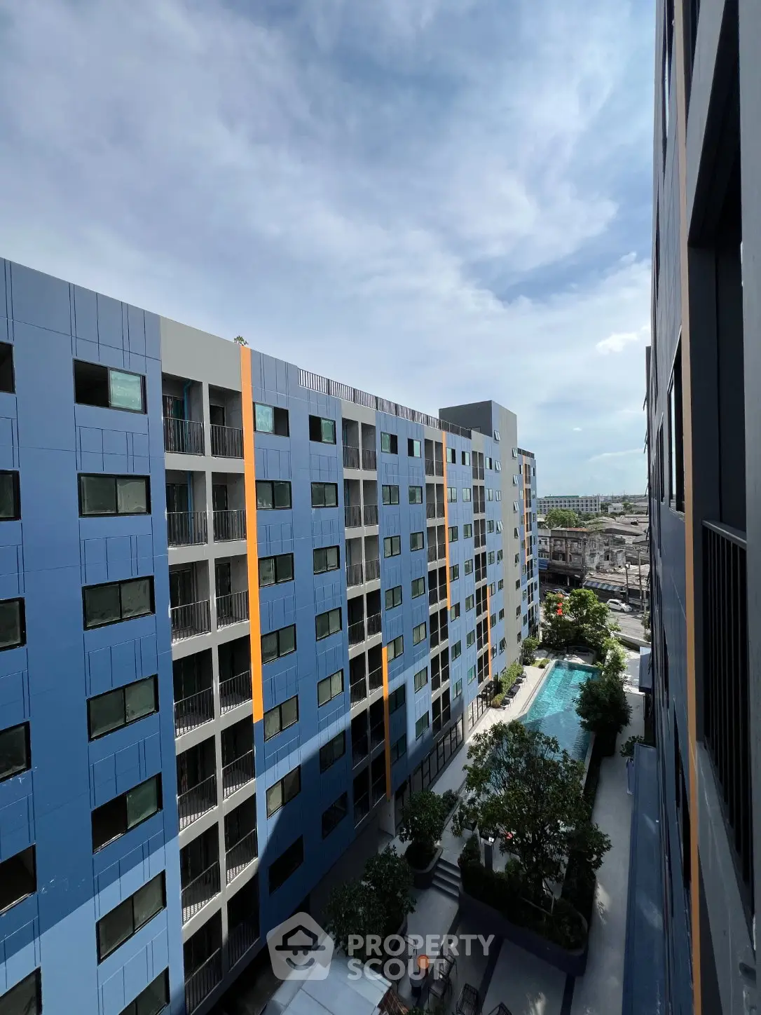Modern apartment complex with pool and city view, showcasing contemporary architecture and urban living.