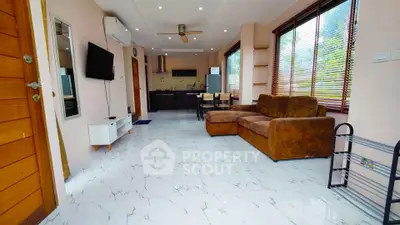 Spacious open-plan living room with modern kitchen and cozy seating area.