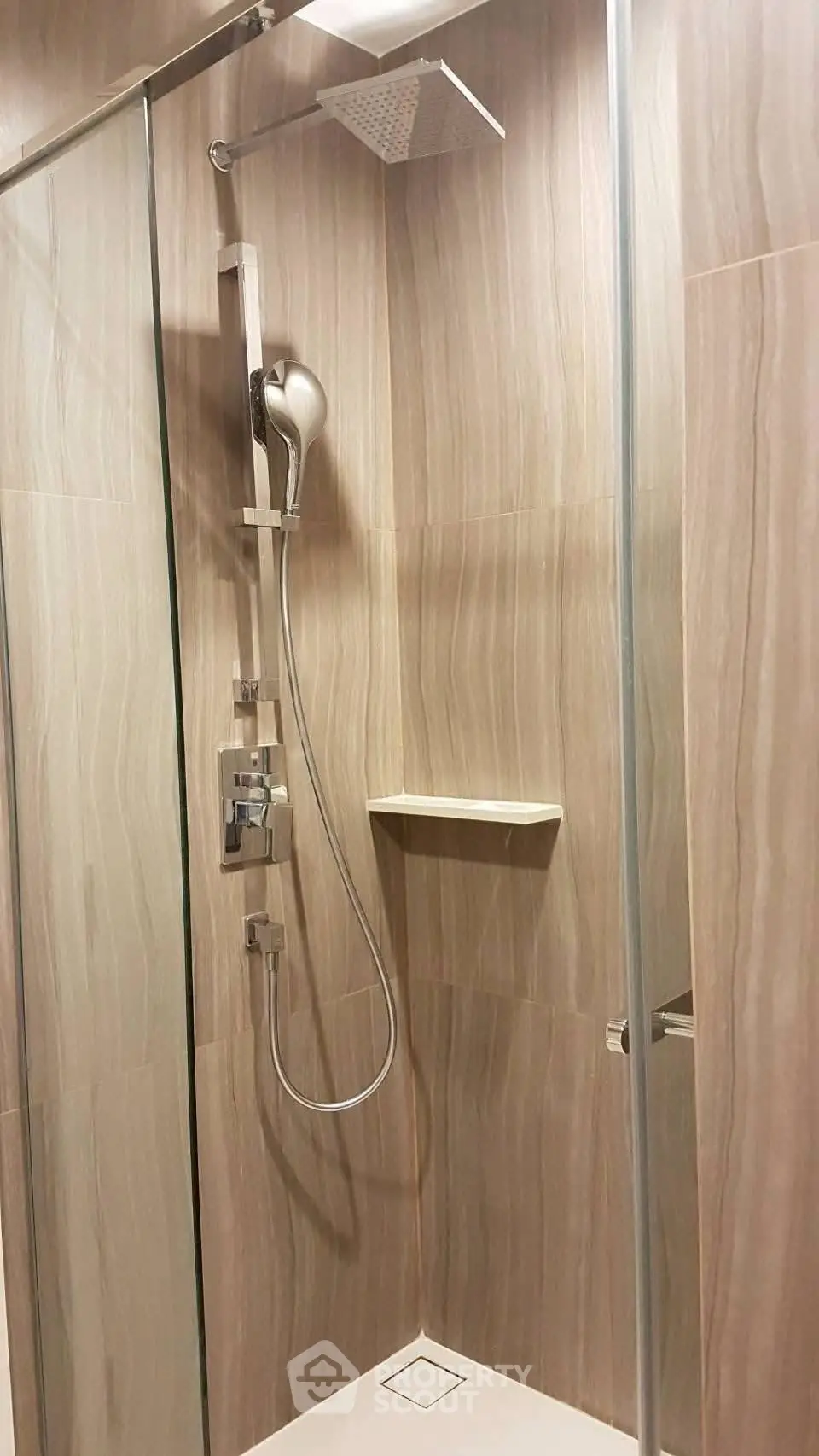 Modern bathroom shower with sleek glass enclosure and elegant tile design.