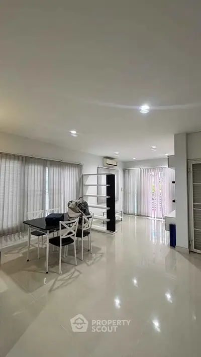 Spacious modern living room with sleek furniture and ample natural light.