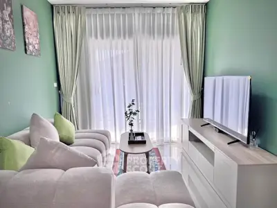 Stylish living room with plush sofa and large TV, perfect for relaxation.