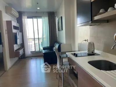 Modern open-layout living room with kitchen, featuring sleek furniture and a city view balcony.