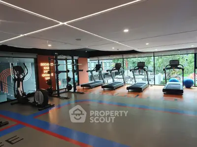 Modern gym with state-of-the-art equipment and large windows offering a scenic view.