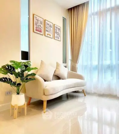 Elegant living room with cozy sofa and large window, perfect for relaxation and natural light.