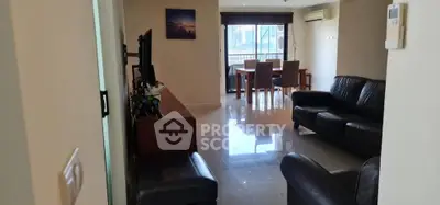 Spacious living room with modern furniture and dining area, featuring a large window for natural light.