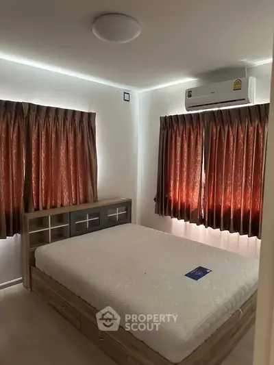 Cozy bedroom with natural light, featuring a comfortable bed and air conditioning for a relaxing retreat.