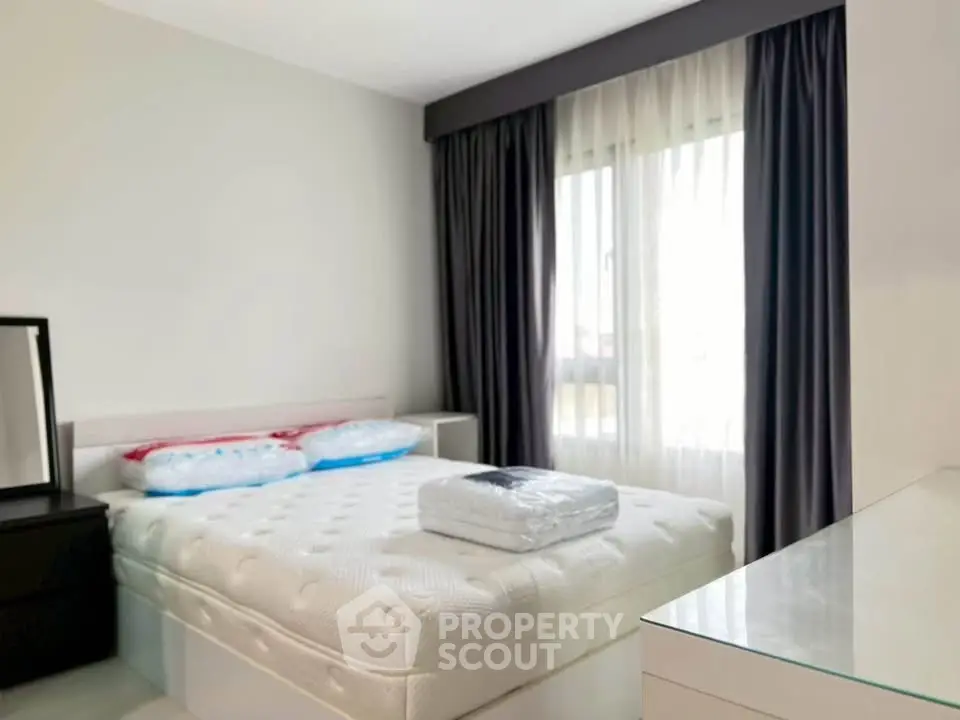 Bright and cozy bedroom with modern furnishings and large window for natural light.