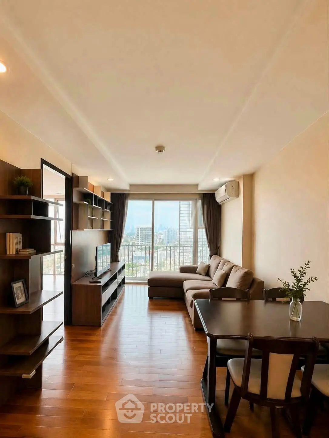 Spacious living room with modern furniture and city view from large windows.
