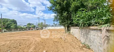 Spacious land plot with potential for development under clear blue skies.