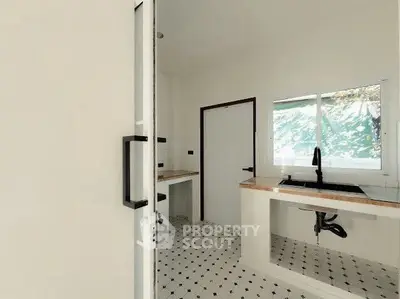 Modern kitchen with minimalist design and large window for natural light.