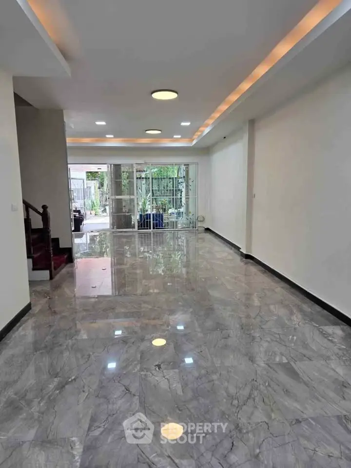 Spacious modern living room with marble flooring and recessed lighting
