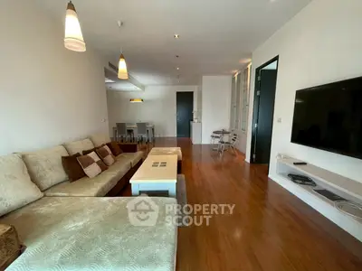 Spacious living room with modern decor and hardwood floors in a stylish apartment.