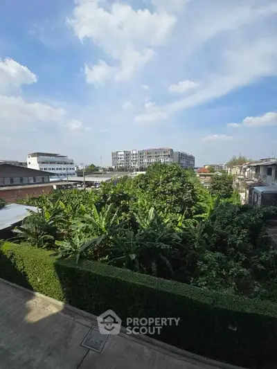 Stunning urban view with lush greenery and modern buildings under a clear blue sky.